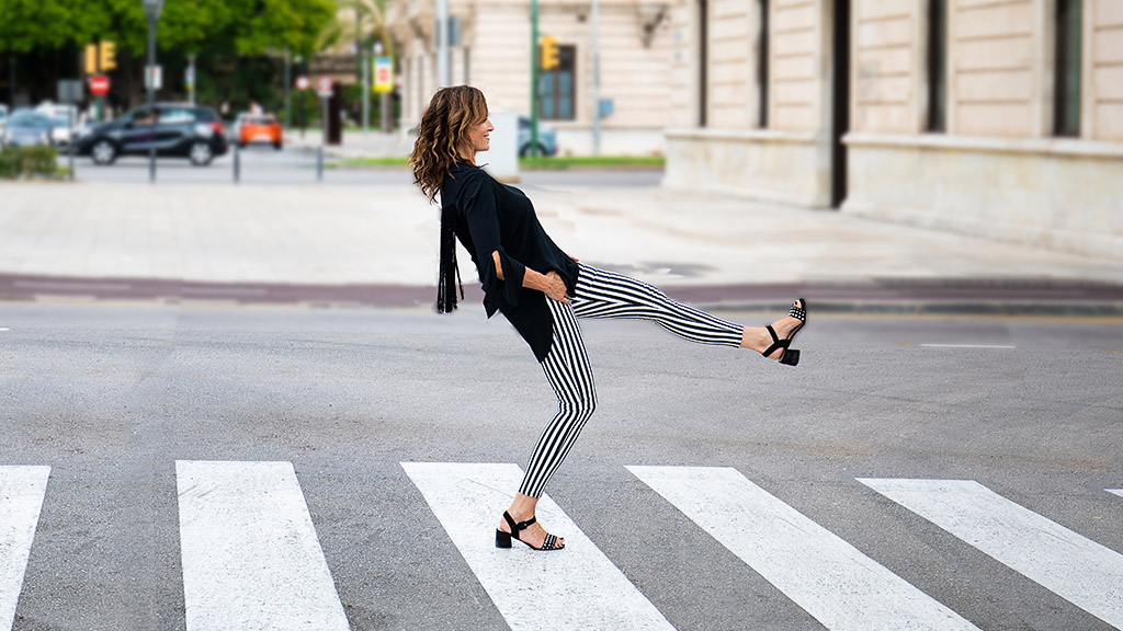 Karin Kuschik läuft über einen Fussgängerüberweg in einer gestreiften Hose